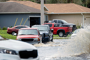 Hurricahe rainfall flooded Florida road with evacuating cars used to illustrate the need to avoid flood damaged cars.