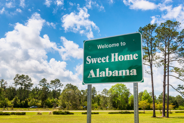 Sweet Home Alabama Road Sign in Alabama with cars on the road to illustrate car insurance in AL