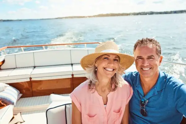 Middle aged couples relaxing on a boat, representing recreational boating, highlighting the importance of understanding boat insurance requirement by state.