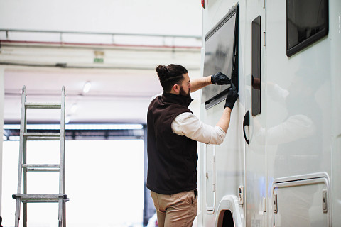 A young man working on his RV to illustrate how easy it is to customize your RV insurance policy with GEICO